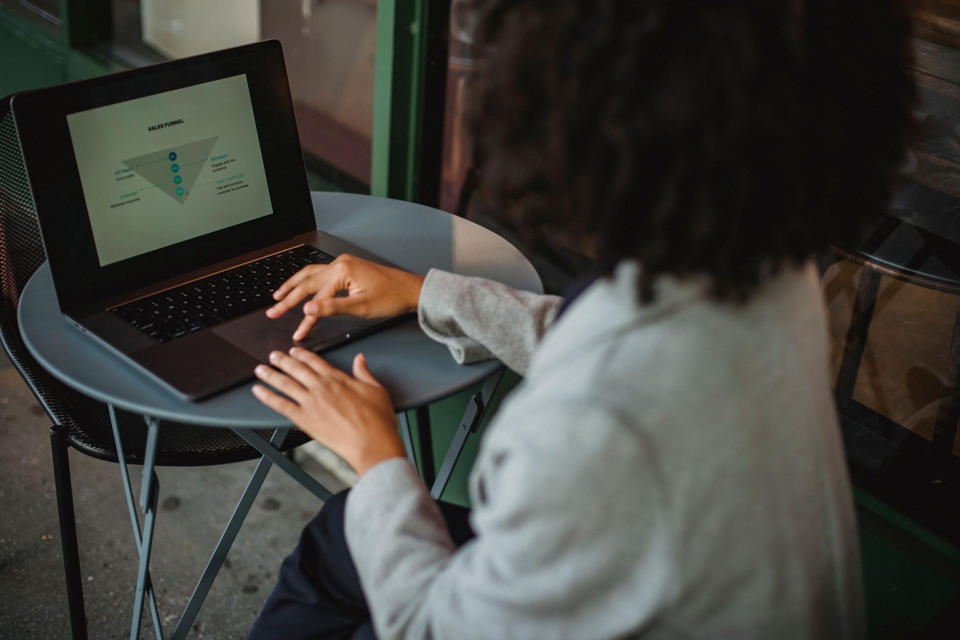Ondernemer werkt aan een laptop op een caféterras